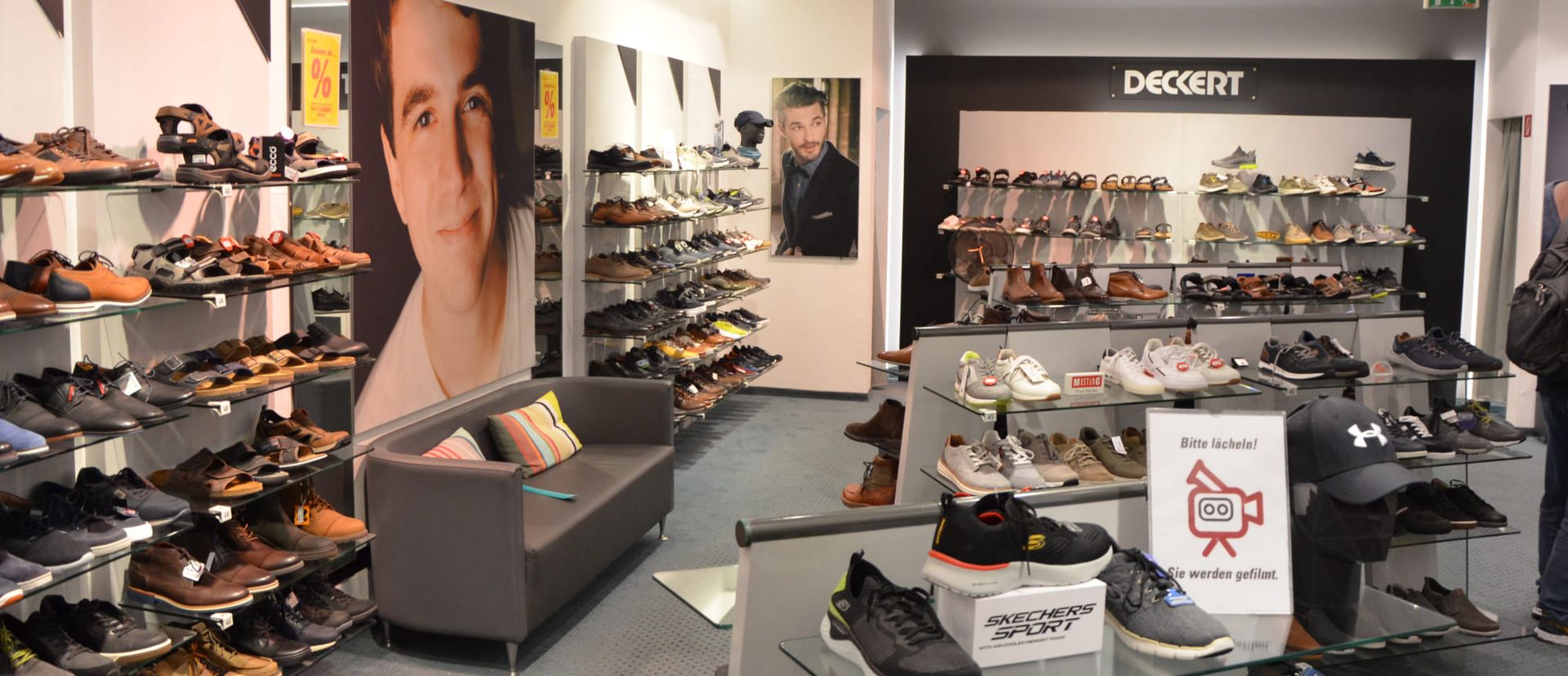 Ein Schuhladen mit vielen Regalen und einer Sitzbank.